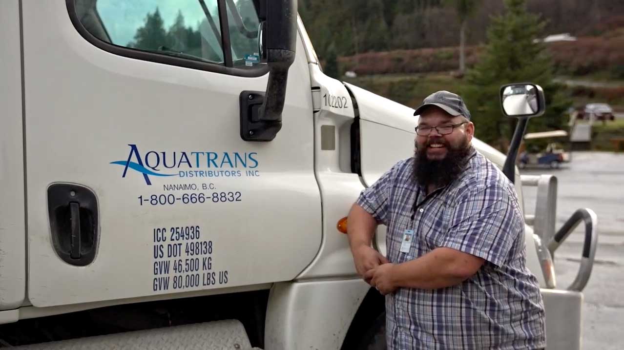 A aquaculture products driver standing outside his truck.
